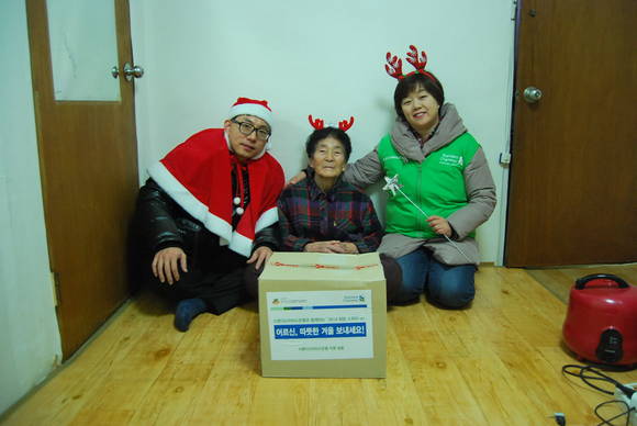 이기경(오른쪽) 스탠다드차타드은행 강북지역본부장이 지난 20일 서울 서대문구에 살고 있는 한 독거노인에게 식료품키트를 전달하고 있다. (사진=SC은행) 