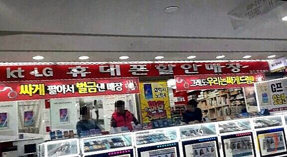 서울 시내에 위치한 휴대폰 판매점 앞에 '싸게 팔아서 벌금낸 매장'이라는 문구가 적혀 있다  