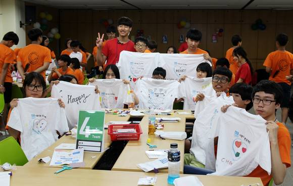 KB금융 ‘KB스타 장학생 경제·금융 캠프’에 참가한 학생들이 나눔봉사활동 시간에 제3세계 어린이들에게 기부하기 위해 직접 꾸민 티셔츠를 들고 있다. (사진=KB금융) 