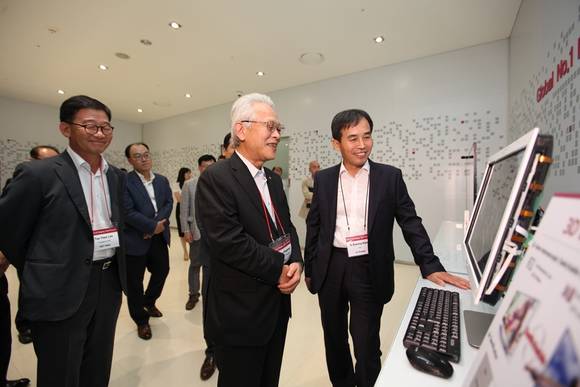LG디스플레이 CTO 강인병 전무(오른쪽)가 Kaneka의 히로사쿠 나가노(Hirosaku NAGANO) 부사장(중앙)과 SKC Haas 이태화 사장(왼쪽)에게 전시 제품을 설명하고 있다.(사진=LGD) 