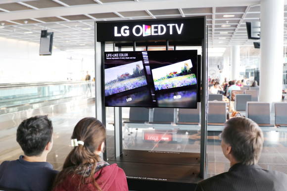 독일 프랑크푸르트에 설치된 LG전자 올레드 TV를 공항 이용객들이 보고 있다.(사진=LG전자) 