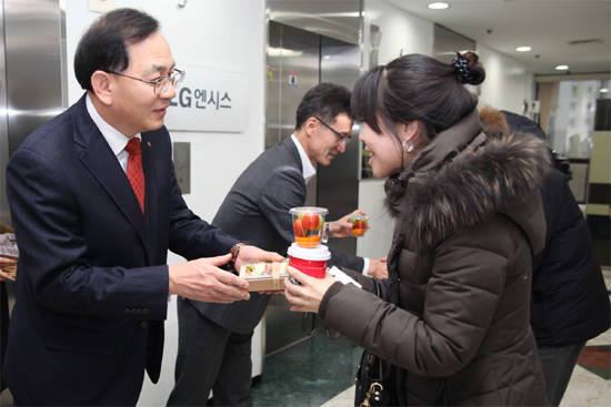 김도현 LG엔시스 사장(왼쪽)이 2016년 새해를 맞아 출근하는 직원들에게 샌드위치를 나눠주며 새해인사를 하고 있다. (사진=LG엔시스) 