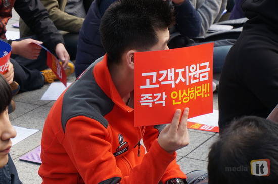 2014년 10월, 전국이동통신유통협회 주최로 열린 '단통법 중단 결의대회'에 참석한 한 참가자가 고객지원금 인상을 요구하고 있는 모습 
