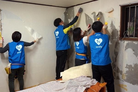 안랩 임직원들이 독거노인 가정의 벽지 도배 봉사활동을 하는 모습. / 안랩 제공