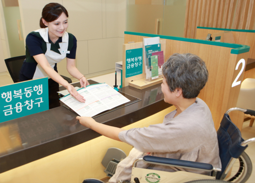 KEB하나은행 창구 직원이 고령의 장애인 고객에게 상담 서비스를 제공하고 있다. / KEB하나은행 제공