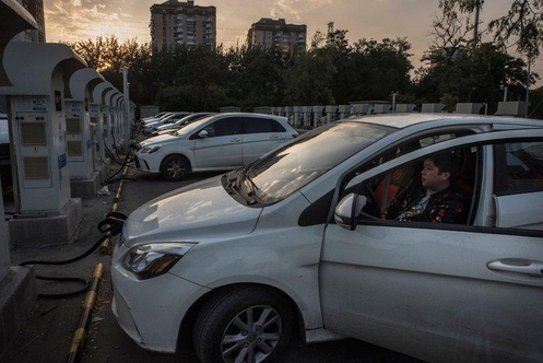 베이징 시내에서 전기차 운전자가 차를 충전하는 모습. / 뉴욕타임즈 갈무리