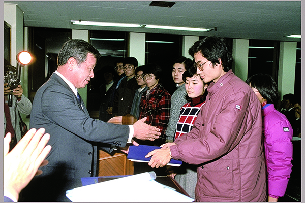  故 최종현 회장이 1986년 해외 유학을 앞둔 한국고등교육재단 장학생들에게 장학증서를 전달하고 있다. / SK 제공