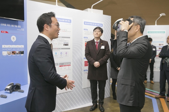 KT 황창규(오른쪽)회장이 2018년 1등 워크숍 성과공유회에서 우수사례로 소개된 VR 스포츠 콘텐츠를 체험하고 있다. / KT 제공