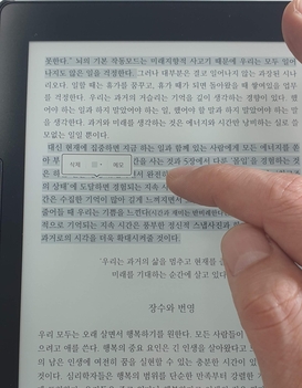 전자책 전용단말기에서 독서중 필요한 대목을 손가락으로 눌러서 표시하는 모습