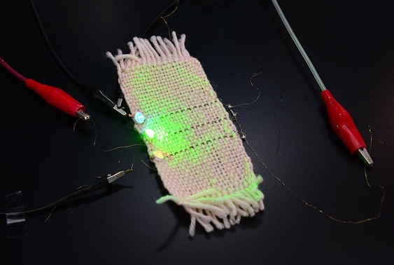 KIST 연구팀이 개발한 새로운 전자섬유로 옷감 위에 붙인 LED를 켠 모습. / KIST 제공