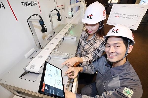 KT 모델이 5G 스마트팩토리 상품을 보여주는 미니 제조 공정라인을 체험하는 모습. / KT 제공