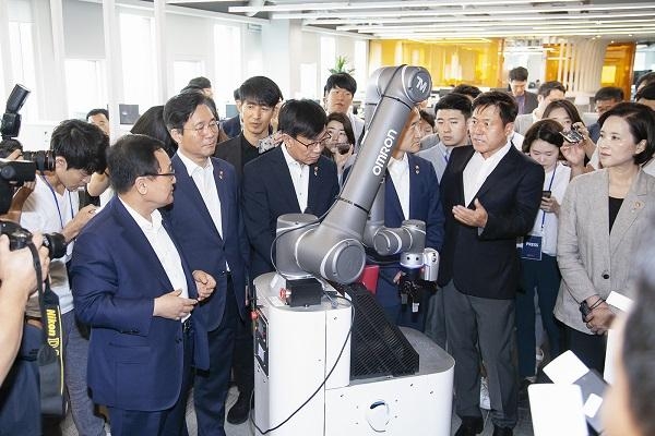 박정호 SK텔레콤 사장(오른쪽 두 번째)이 5G 딜리버리 로봇을 장관들에게 소개하고 있다. / SK텔레콤 제공
