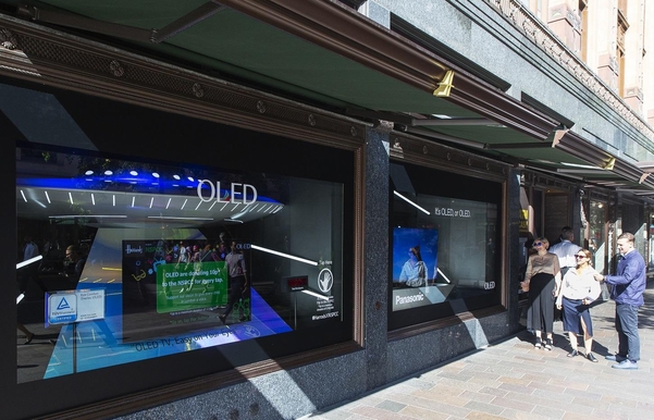 LG디스플레이가 영국 해롯백화점 1층 쇼윈도에 전시 OLED TV를 방문객들이 관람하고 있다./자료 LG디스플레이
