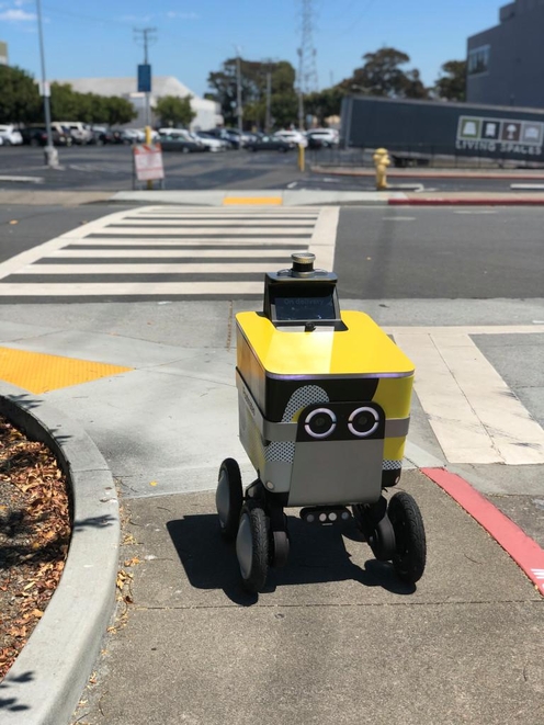 포스트메이츠의 자율주행로봇 ‘서브로봇'이 거리에서 배송하는 모습./자료 테크크런치