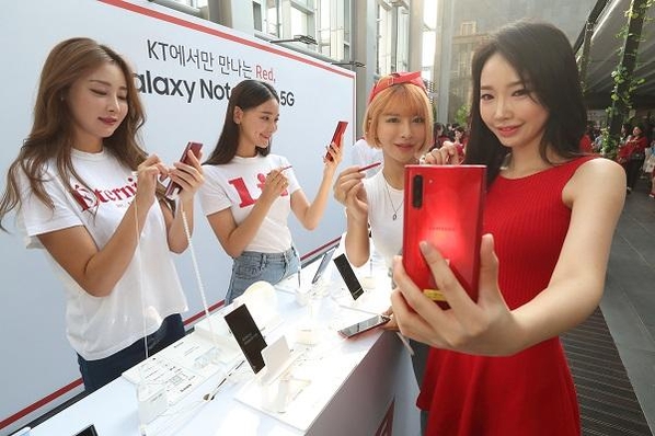 19일 노보텔 앰배서더 서울 동대문에서 열린 ‘갤럭시 노트10 5G’ 출시 기념 론칭 파티에서 KT 모델이 ‘아우라 레드’ 색상의 갤럭시 노트10 5G를 보고 있다. / KT 제공