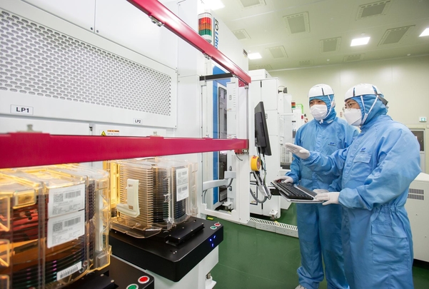 반도체 레이저 설비를 살펴보는 삼성전자 직원(오른쪽)과 이오테크닉스 직원(왼쪽) / 삼성전자