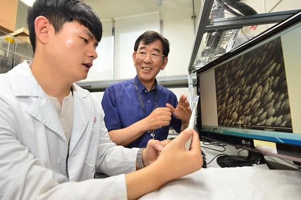 이중기 KIST 책임연구원(오른쪽)과 김지영 KIST 연구원이 아연 금속의 표면처리 기술을 통해 육각뿔 피라미드 모양의 형상을 형성한 표면의 현미경 이미지를 확인하고 있다./ KIST