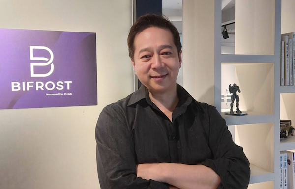 박도현 파이랩 대표가 블록체인 기술 프로젝트 ‘바이프로스트’ 로고 앞에서 자세를 취하고 있다. / 파이랩