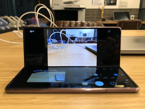 기기를 90도로 구부린 후 후면 카메라로 사진을 촬영하는 모습. 위쪽 화면에서 카메라 촬영이 가능하고 아래 화면에서는 촬영한 사진을 바로 확인할 수 있다. / 김평화 기자