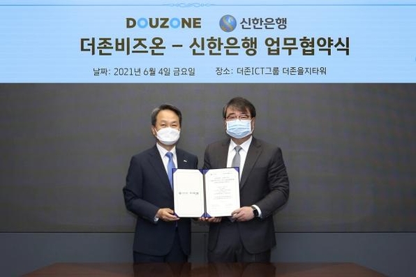 김용우 더존비즈온 대표(오른쪽)와 진옥동 신한은행 은행장이 협약서를 교환하고 있다. / 더존비즈온