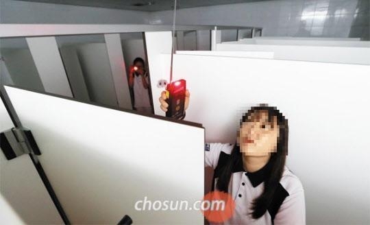 서울의 한 대학 화장실에서 몰카를 조사하고 있는 학교 보안 직원의 모습. / 조선DB