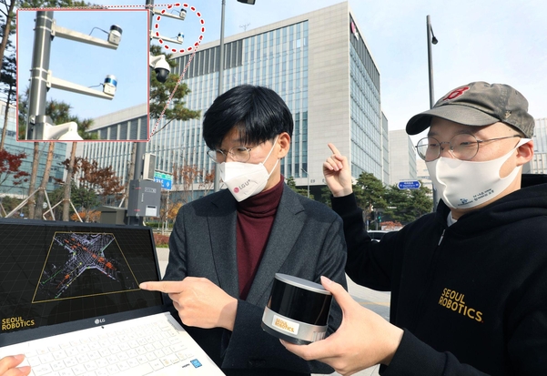 주영준 LG유플러스 차세대기술Lab장(왼쪽)과 이한빈 서울로보틱스 대표가 LG유플러스 마곡사옥 앞 교차로에 설치된 LiDAR 센서를 살피고 있다. / LG유플러스