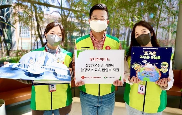 봉사활동에 참여한 롯데하이마트 임직원들이 환경 보호 교육 팝업북을 소개하고 있다. / 롯데하이마트