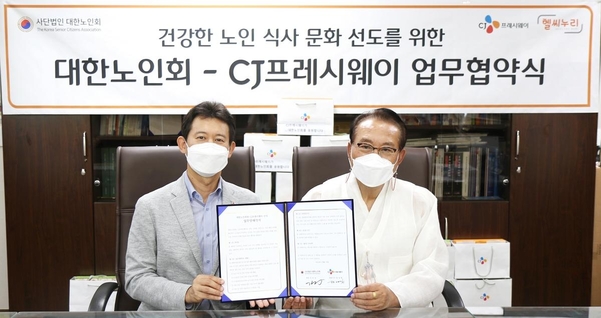 정성필 CJ프레시웨이 대표(왼쪽)와 김호일 대한노인회 회장이 업무협약을 체결하고 기념촬영을 하고 있다. / CJ프레시웨이