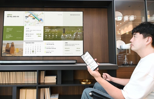 LG전자 모델이 LG 씽큐 앱에서 ‘모닝브리핑’ 서비스를 실행해 LG 스마트 TV의 화면을 통해 날씨/교통/일정/메모/차량 등의 정보를 확인하고 있는 모습 / LG전자