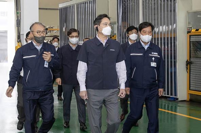 28일 이재용 회장과 김보곤 디케이 대표(맨 오른쪽)가 디케이 생산 라인을 둘러보고 있다 / 삼성전자