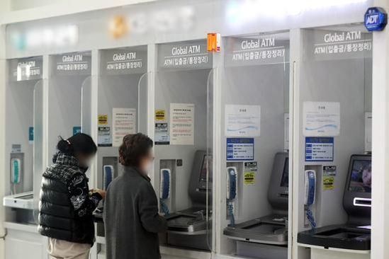 서울 시내 한 건물에 설치된 은행의 현금인출기(ATM)에서 시민들이 입출금을 하는 모습. / 뉴스1