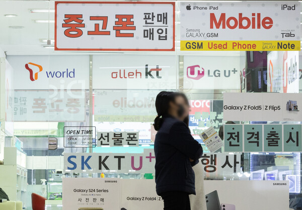 지난 1월 22일 서울의 한 핸드폰 매장 앞으로 시민들이 지나가고 있다. / 뉴스1