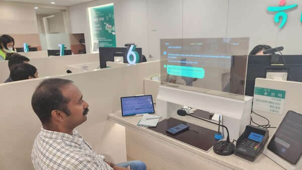 22일 하나은행 평택외국인센터점 내 설치된 AI 통번역 시스템과 투명 디스플레이를 이용해 한 고객이 상담을 받고 있다. / 김홍찬 기자