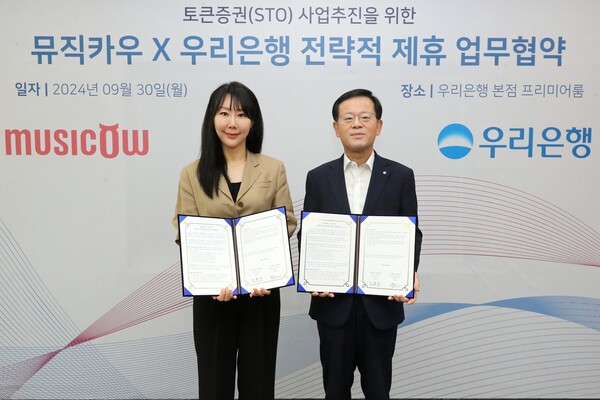 우리은행은 지난 30일 우리은행 본점에서 뮤직카우와 업무협약을 체결했다. 우리은행 조병규 은행장(오른쪽)이 뮤직카우 정현경 대표이사와 기념촬영을 하고 있다. / 사진 = 우리은행