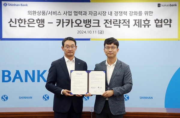 지난 11일 서울시 중구 신한은행 본점에서 진행된 ‘신한은행-카카오뱅크 전략적 제휴 협약식’에서 신한은행 김광수 고객솔루션 그룹장(왼쪽)과 카카오뱅크 이형주 최고비즈니스책임자(오른쪽)가 기념촬영 하는 모습 / 신한은행