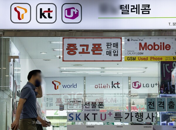 시민들이 9월 6일 서울의 한 휴대폰 판매 대리점 앞을 지나가고 있다. / 뉴스1