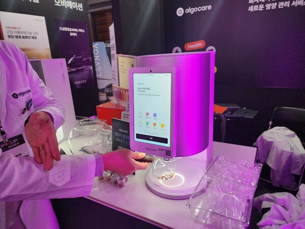 알고케어 관계자가 맞춤형 영양제 배급 기기를 시연하고 있다. / 김홍찬 기자
