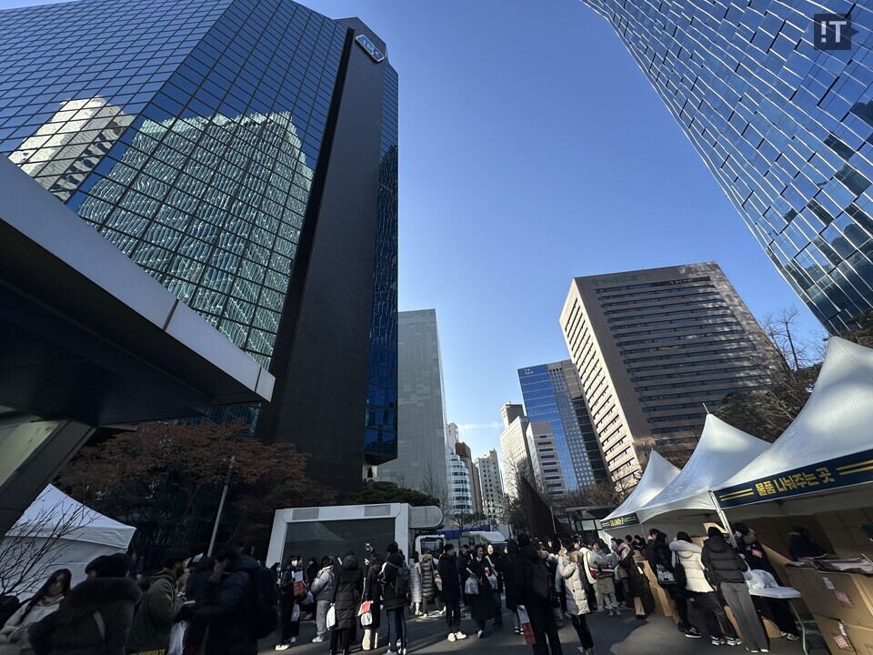 IBK기업은행 을지로 본관 주차장에서 집회 참가자들이 집회 관련 물품을 배부 받고 있다. / 김경아 기자
