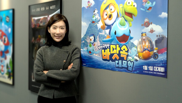 우지희 오콘 대표가 뽀로로 극장판 바닷속 대모험 포스터 앞에서 사진을 촬영하고 있다. / 오콘