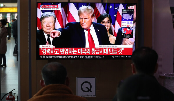 2024년 11월 6일 오후 서울역에서 시민들이 도널드 트럼프 대통령 당선인의 지지자 연설 생중계를 보고 있다. / 뉴스1