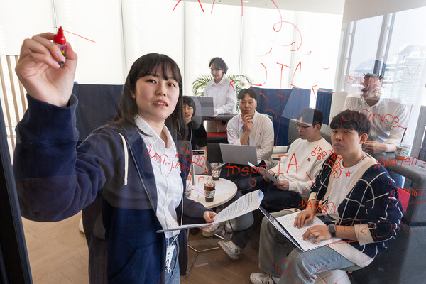 KT 인공지능 전환(AX) 딜리버리 전문센터 직원들이 글로벌 선도 기업 내 최고 전문가들과 공동 프로젝트를 준비하고 있다. / KT