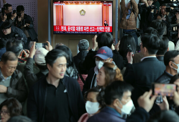 윤석열 대통령 탄핵심판 선고일인 4일 서울 중구 한강대로 서울역 대합실에서 시민들이 헌법재판소의 탄핵심판 선고 생중계를 시청하고 있다. / 사진 = 뉴스1