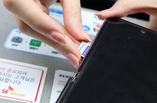 28일 오전 인천공항 제2터미널 SKT매장에서 해킹 공격으로 가입자 유심 정보가 탈취된 SK텔레콤 고객이 유심을 교체하고 있다. / 뉴스1
