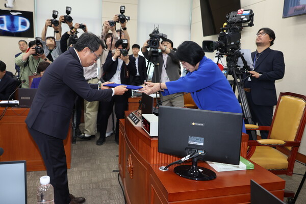 유영상(왼쪽) SK텔레콤 대표가 8일 오후 서울 여의도 국회 과학기술정보방송통신위원회에서 열린 SK텔레콤 해킹 관련 청문회에 출석해 증인 선서 후 최민희 위원장에게 선서문을 제출하고 있다. / 뉴스1