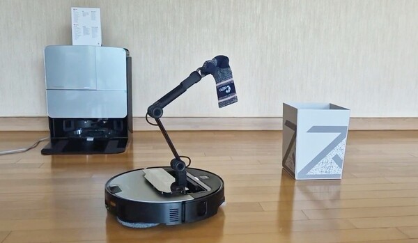 세계 최초의 로봇 팔이 달린 청소기 사로스 Z70이 바닥에 떨어진 양말을 자동으로 인식하고 로봇팔을 이용해 양만을 물건 정리함으로 옮기고 있다. / 이선율 기자