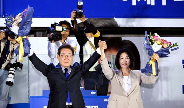 이재명 더불어민주당 대통령 후보와 부인 김혜경 여사가 4일 오전 당선이 확실시되자 서울 여의도 국회 앞을 찾아 꽃다발을 받아 들어보이고 있다./뉴스1