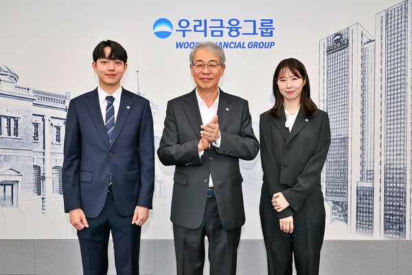 우리금융그룹 임종룡 회장이 그룹의 새 가족이 된 동양생명·ABL생명 직원에게 디지털 선도의 의미가 담긴 새로운 그룹 보조휘장을 달아주고 있다./우리금융그룹