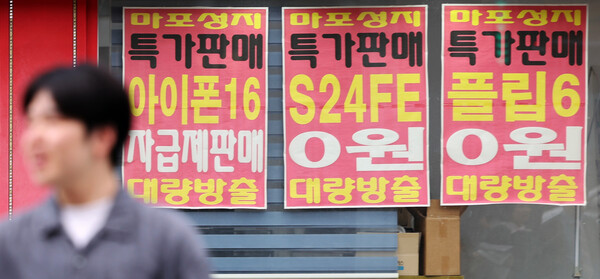 A citizen moves in front of a mobile phone store in downtown Seoul on the afternoon of July 20. / News 1