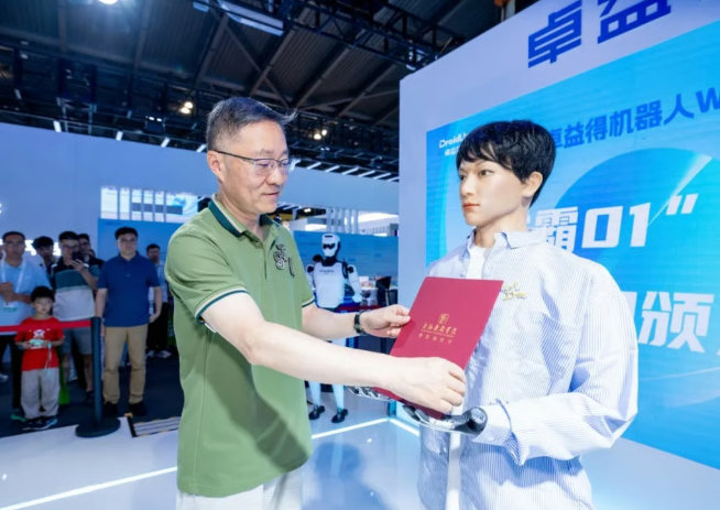 양칭칭 상하이극예학원 교수가 휴머노이드 로봇 쉐바 01에게 입학증을 수여하는 모습 / 상하이극예학원