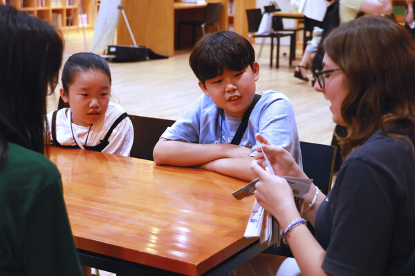 지난 7월 19일 경기도 파주시 ‘지혜의 숲’에서 진행된 ‘영어 동화작가 되기 원데이클래스’에서 체험단 참가자들이 원어민 선생님이 진행하는 스토리텔링 수업을 듣고 있다. / 웅진그룹